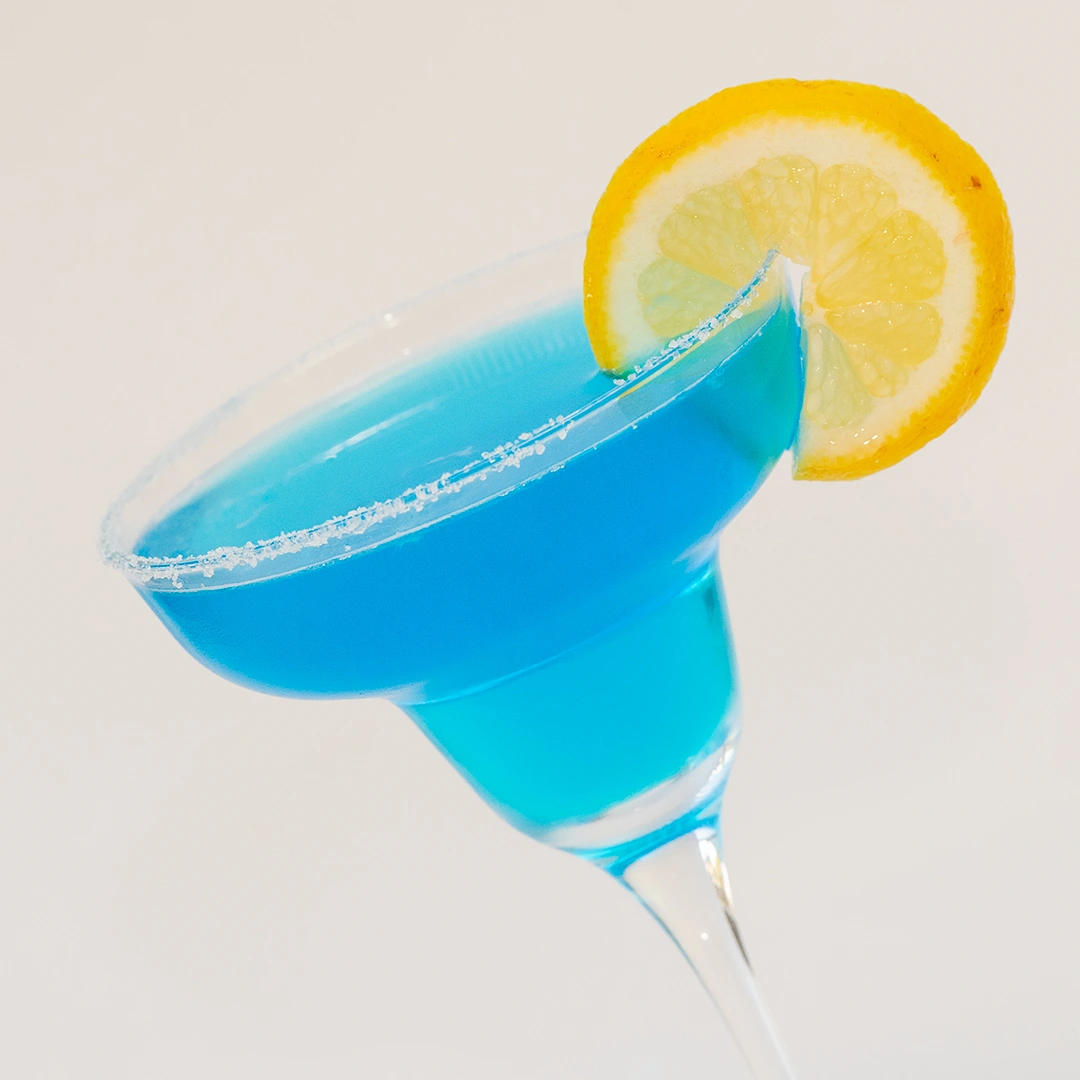 Si vede un curioso cocktail dal colore blu a base di Blue Curaçao